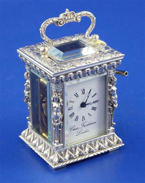 An ornate cast silver cased brass miniature carriage timepiece retailed by Charles Frodsham & Co, London, 4in inc. handle.